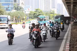 Người tham gia giao thông phải tránh nắng dưới bóng râm của gầm cầu trên tuyến đường Phạm Hùng. (Ảnh: Thành Đạt/TTXVN)
