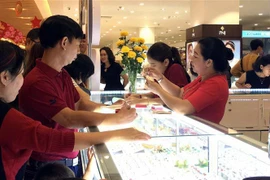 Khách hàng chọn trang sức làm quà tặng. (Ảnh: Thanh Vũ/TTXVN)