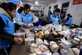 Công nhân đóng gói hàng hóa tại một công ty chuyển phát ở tỉnh Giang Tô, miền Đông Trung Quốc. (Ảnh: THX/TTXVN)