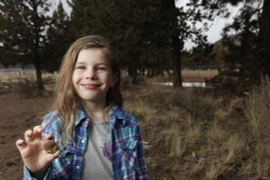 Naomi cầm mẫu hóa thạch cô bé tìm thấy. (Nguồn: AP)