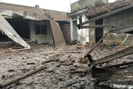 Nhiều ngôi nhà gần khu vực kho chứa phế liệu đã bị sập mái, bay cửa; nhiều mái tôn bay xa hàng chục mét do vụ nổ gây ra. (Ảnh: Thái Hùng/TTXVN)
