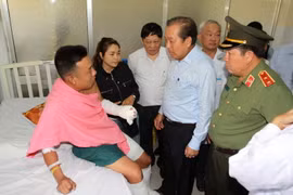 Phó Thủ tướng Thường trực Chính phủ Trương Hoà Bình thăm hỏi, động viên Đại úy Trần Tuấn Thanh bị thương trong khi làm nhiệm vụ đang được điều trị tại Bệnh viện Chợ Rẫy. (Ảnh: Thanh Vũ/TTXVN)