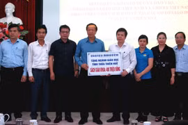 Bộ Giáo dục và Đào tạo trao tặng sách giáo khoa cho học sinh vùng lũ. (Ảnh: Tường Vi/TTXVN)