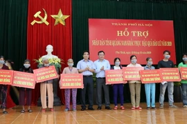 Người dân huyện Phú Ninh, tỉnh Quảng Nam bị thiệt hại do bão lũ nhận quà hỗ trợ từ Hà Nội. (Ảnh: Trần Tĩnh/TTXVN)