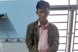 Đối tượng Trần Minh Thành bị bắt giữ cùng các tang vật. (Ảnh: TTXVN phát)