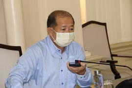 Ông Đoàn Tấn Bửu gọi điện thoại trực tiếp cho lực lượng y tế đang trực tiếp làm nhiệm vụ tại cơ sở để cập nhật tình hình. (Ảnh: Chương Đài/TTXVN)