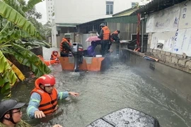 Lực lượng chức năng sơ tán 200 hộ dân phường Bến Thủy, thành phố Vinh đến nơi an toàn. (Ảnh: Bích Huệ/TTXVN)