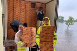 Vận chuyển lương thực hỗ trợ người dân vùng lũ. (Ảnh: TTXVN phát)