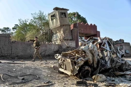 Lực lượng an ninh Afghanistan điều tra tại hiện trường một vụ đánh bom xe. (Ảnh: AFP/TTXVN)
