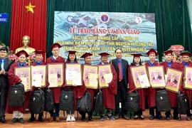 Trao chứng chỉ hành nghề và tặng quà của Bộ trưởng Bộ Y tế cho các bác sỹ tốt nghiệp. (Ảnh: PV/TTXVN)