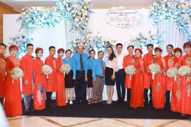 Ông Hồ Xuân Lâm, Phó Chủ tịch Liên đoàn Lao động TP Hồ Chí Minh với các đại biểu cùng các cô dâu, chú rể tại lễ cưới tập thể. (Ảnh: Thanh Vũ/TTXVN)