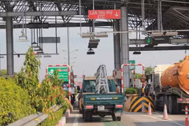 Phương tiện dán thẻ thu phí tự động đi vào làn đường của trạm thu phí được lắp đặt thu phí tự động. (Ảnh: Việt Hùng/Vietnam+)