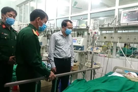 Phó Chủ tịch UBND tỉnh Hà Giang Trần Đức Quý thăm hỏi, động viên chiến sỹ bị thương khi làm nhiệm vụ rà phá bom mìn đang nằm điều trị tại Bệnh viện Đa khoa tỉnh Hà Giang. (Ảnh: TTXVN phát)