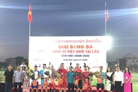 Đại diện Đại sứ quán Việt Nam tại Lào cùng các đại biểu tặng hoa và cờ lưu niệm cho tổ trọng tài và 7 đội tham dự giải. (Ảnh: Thu Phương/TTXVN)
