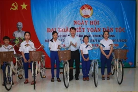 Ông Nguyễn Đức Lợi, Ủy viên Trung ương Đảng, Tổng Giám đốc TTXVN, trao xe đạp cho các em học sinh ở xã Triệu Trung. (Ảnh: Hồ Cầu/TTXVN)