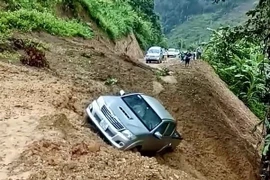 Chiếc xe ôtô bán tải bị đất đá sạt lở cuốn trôi xuống vực. (Ảnh: TTXVN phát)