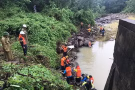 Lực lượng chức năng tiến hành trục vớt thi thể anh Thái Bá Thuận. (Ảnh: TTXVN phát)