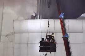Lính cứu hỏa giải cứu người dân trong vụ hỏa hoạn tổ hợp sòng bài và khách sạn Grand Diamond City ở thành phố Poipet của Campuchia, sáng 29/12. (Ảnh: AFP/TTXVN)