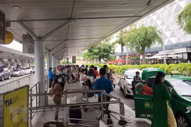 Hành khách chờ đón xe công nghệ, taxi tại sân bay Tân Sơn Nhất. (Ảnh: Tiến Lực/TTXVN)