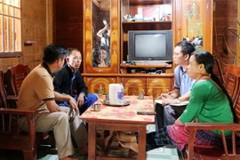 Lãnh đạo xã Tà Tổng, huyện Mường Tè thăm, hỏi gia đình anh Và Nhè Chứ, ở bản Pà Khà, xã Tà Tổng, huyện Mường Tè. (Ảnh: Hoàng Thùy Oanh/TTXVN)