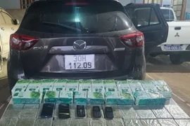 Chiếc xe đối tượng sử dụng và tang vật bị thu giữ. (Ảnh: TTXVN phát)