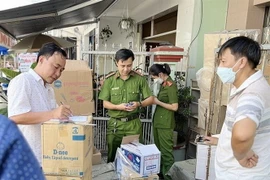 Lực lượng công an kiểm đếm số lượng hàng hóa nghi vấn nhập lậu. (Ảnh: TTXVN phát)