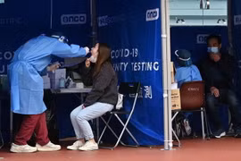 Nhân viên y tế lấy mẫu xét nghiệm COVID-19 cho người dân tại Hong Kong, Trung Quốc. (Ảnh: AFP/TTXVN)