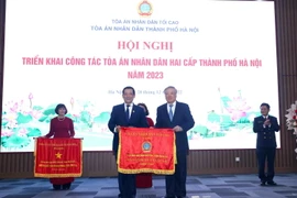 Chánh án Tòa án Nhân dân Tối cao Nguyễn Hòa Bình trao Cờ thi đua của Tòa án Nhân dân Tối cao cho các đơn vị có thành tích xuất sắc. (Ảnh: Phạm Kiên/TTXVN)