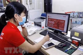 Nhân viên siêu thị nhận cuộc gọi mua hàng online từ khách hàng. (Ảnh: Hoàng Hùng/TTXVN)