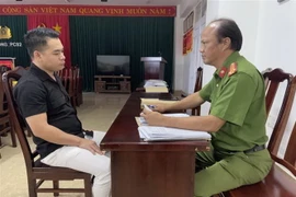 Đối tượng Nguyễn Thanh Toàn làm việc tại cơ quan công an. (Ảnh: TTXVN phát)