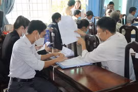 Các hộ dân trao đổi với cán bộ phụ trách về việc bồi thường, hỗ trợ tái định cư. (Ảnh: Minh Trí/TTXVN)