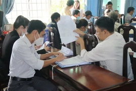 Các hộ dân trao đổi với cán bộ phụ trách về việc bồi thường, hỗ trợ tái định cư. (Ảnh: Minh Trí/TTXVN)