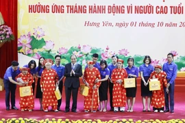 Chủ tịch nước Nguyễn Xuân Phúc tặng quà các cụ cao tuổi tại buổi lễ. (Ảnh: Thống Nhất/TTXVN)