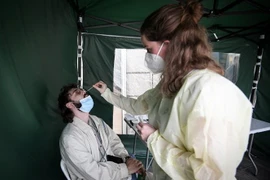 Nhân viên y tế lấy mẫu xét nghiệm COVID-19 cho người dân tại Paris, Pháp. (Ảnh: AFP/TTXVN)