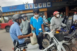 Người dân mang can đi mua xăng. (Ảnh: TTXVN)