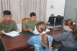 Chị Võ Thị Dợn và con gái Võ Ngọc Lan Thảo làm việc với lực lượng công an. (Ảnh: TTXVN phát)