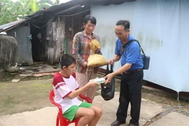 Thầy Lê Trung Lành đến tận nhà trao quà cho các trẻ em có hoàn cảnh đặc biệt khó khăn. (Ảnh: Lê Thúy Hằng/TTXVN)