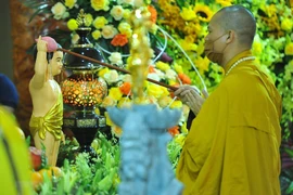 Các hòa thượng và chư tôn đức thực hiện nghi lễ tắm Phật đản sinh. (Ảnh: Minh Đức/TTXVN)