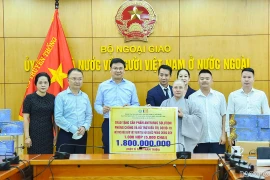 Thứ trưởng Ngoại giao Phạm Quang Hiệu, Chủ nhiệm Ủy ban Nhà nước về người Việt Nam ở nước ngoài tiếp nhận sản phẩm hỗ trợ điều trị COVID-19. (Nguồn: Báo Quốc tế)