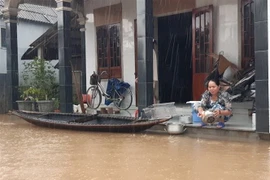 Người dân 'rốn lũ' Xuân Tùy, huyện Quảng Điền, tỉnh Thừa Thiên-Huế thích nghi với mưa lũ sau nhiều ngày bị ngập lụt. (Ảnh: Mai Trang/TTXVN)