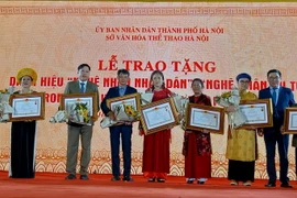 Trao tặng bằng vinh danh nghệ nhân ưu tú cho các nghệ nhân trong lĩnh vực di sản văn hóa phi vật thể ở Hà Nội. (Ảnh: Đinh Thuận/TTXVN)