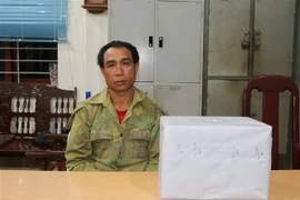 Đối tượng Thong Si và tang vật tại cơ quan công an. (Ảnh: TTXVN phát)