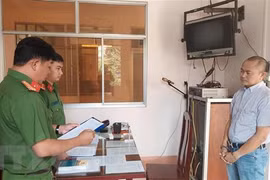 Cơ quan Cảnh sát điều tra Công an huyện Châu Thành (tỉnh Đồng Tháp) đọc lệnh khởi tố, bắt tạm giam bị can Trần Lập Nghĩa. (Ảnh: TTXVN phát)