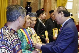 Chủ tịch nước Nguyễn Xuân Phúc tặng chân dung Chủ tịch Hồ Chí Minh cho đại biểu người có uy tín tiêu biểu tỉnh Hà Giang. (Ảnh: Thống Nhất/TTXVN)