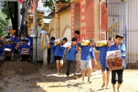 Các đoàn viên, thanh niên tích cực vận chuyển các mặt hàng thiết yếu, giúp người dân vùng lũ ở Kỳ Sơn vượt qua khó khăn. (Ảnh: Văn Tý/TTXVN)