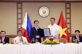 Chủ tịch Hạ viện Martin Romualdez trao Nghị quyết số 571 về tăng cường hợp tác giữa Philippines và Việt Nam với việc thành lập Nhóm Nghị sỹ hữu nghị Philippines-Việt Nam cho Chủ tịch Quốc hội Vương Đình Huệ. (Ảnh: Doãn Tấn/TTXVN)