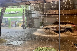 Nước ngập gần nửa bánh xe hơi trên đường Linh Đông, thành phố Thủ Đức. (Ảnh: Hồng Giang/TTXVN)