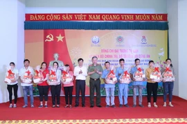 Đại tướng Tô Lâm, Ủy viên Bộ Chính trị, Bộ trưởng Bộ Công an và Bí thư Tỉnh ủy Tây Ninh Nguyễn Thành Tâm (áo trắng) tặng quà Tết cho công nhân. (Ảnh: Thanh Tân/TTXVN)