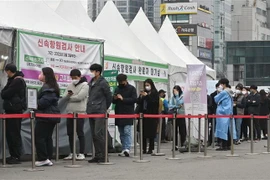 Người dân xếp hàng chờ xét nghiệm COVID-19 tại Seoul, Hàn Quốc. (Ảnh: AFP/TTXVN)