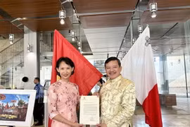 Đại diện Đại sứ quán Việt Nam tại Italy kiêm nhiệm Malta trao thư chúc mừng thành lập Hội người Việt Nam tại Malta của Thứ trưởng Ngoại giao Phạm Quang Hiệu cho Chủ tịch Hội Nguyễn Hoài Nam. (Ảnh: Dương Hoa/TTXVN)